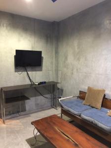 ein Wohnzimmer mit einem Sofa und einem TV in der Unterkunft Beach Way Apartment in Koh Samui 
