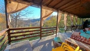 a screened in porch with a view of the mountains at Pensiunea Poiana Marului - Bisoca in Bisoca