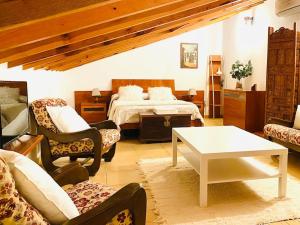 Schlafzimmer mit einem Bett, einem Tisch und Stühlen in der Unterkunft Casa Rustica con Encanto in Navalcarnero