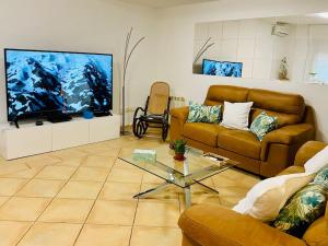 uma sala de estar com 2 sofás e uma televisão de ecrã plano em Casa Rustica con Encanto em Navalcarnero