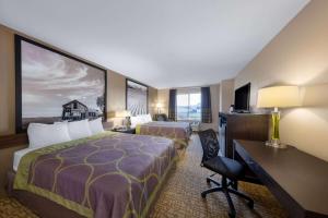 ein Hotelzimmer mit 2 Betten und einem Schreibtisch in der Unterkunft Super 8 by Wyndham Jackson MN in Jackson