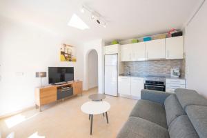 un soggiorno con divano e cucina di Apartamento Felicidad - PlusHolidays a La Canuta