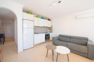 un soggiorno con un divano e un tavolo di Apartamento Felicidad - PlusHolidays a La Canuta Altre 3 foto