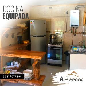 kuchnia z lodówką i stołem z płytami w obiekcie Cabañas Alto Cordillera w mieście Las Trancas