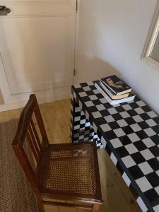 a table with a chair and a table with a checkered floor at La petite maison de Savennières in Savennières