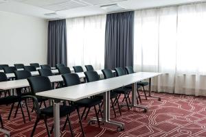 a conference room with white tables and chairs at Scandic Södertälje in Södertälje