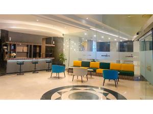 a lobby with a table and chairs and a counter at Malyabhara Hotel - formerly Ibis Malioboro in Yogyakarta