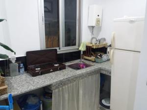 a kitchen counter with a sink and a refrigerator at Dar Ba Brahim in Rabat