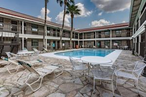 a patio with tables and chairs next to a pool at La Quinta Inn by Wyndham Laredo I-35 in Laredo