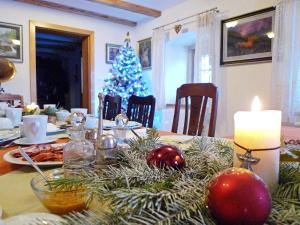 a dining room table with a christmas tree and a candle at Osada Jeździecka Bata in Mirsk
