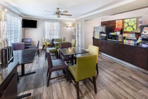 a restaurant with tables and chairs and a bar at La Quinta Inn by Wyndham Laredo I-35 in Laredo