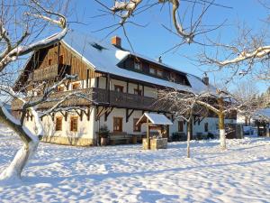 a large building in the snow with snow covered trees at Osada Jeździecka Bata in Mirsk