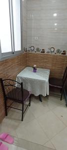 - une table avec deux chaises et un vase pourpre dans l'établissement Dar Ba Brahim, à Rabat
