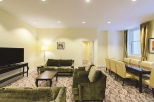 a living room with couches and a flat screen tv at Rendezvous Hotel Melbourne in Melbourne