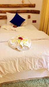 Una cama blanca con flores encima. en Rangali Etos Guraidhoo en Guraidhoo