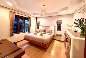 a bedroom with a bed and a large window at Three rare & private front beach villas in Thong Sala