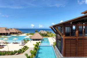 InterContinental Dominica Cabrits Resort & Spa, an IHG Hotel في بورتسموث: اطلالة جوية على المنتجع مع المحيط في الخلفية