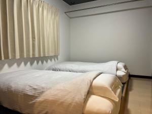 two twin beds in a room with a window at ＡkＢ63 in Sapporo