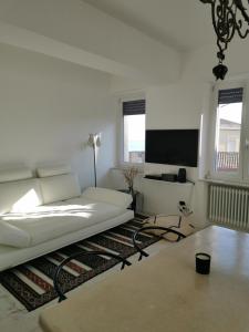 uma sala de estar com um sofá branco e uma televisão de ecrã plano em A Barunedda - charming house with terrace em Taormina
