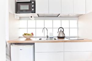 eine Küche mit weißen Schränken und einer Spüle in der Unterkunft Widok na basen, Home-Office, Wi-Fi Gratis in Costa Calma