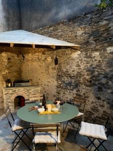 a table and chairs in front of a stone wall at La petite maison de Savennières in Savennières