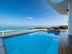 a swimming pool with a view of the ocean at Boutique Ocean Views Guesthouse in Hermanus