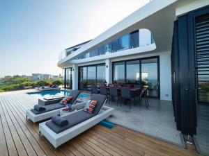 a modern house with a deck with a dining room at Boutique Ocean Views Guesthouse in Hermanus