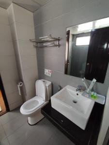 une salle de bain avec toilettes, lavabo et miroir dans l'établissement Awesome Homestay Apartment @ Equatorial Hill Resort, à Brinchang 3 autres photos