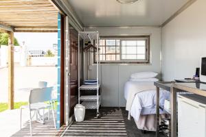 a bedroom with a bed and a table and chairs at Kite Basecamp Langebaan in Langebaan