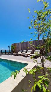 a swimming pool with lounge chairs next to the ocean at Carppa Hotel in Fortaleza