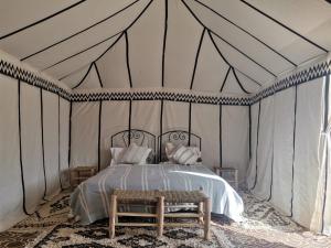 a bedroom with a bed in a tent at Sun Bivouac Chegaga in El Gouera