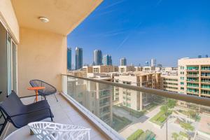 einen Balkon mit Stühlen und Stadtblick in der Unterkunft Daniels 2BR The Greens Park View in Dubai