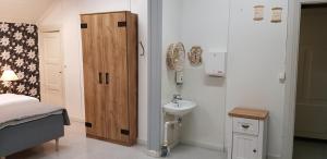 baño pequeño con lavabo y cama en Kokon Hovi en Kauhajoki