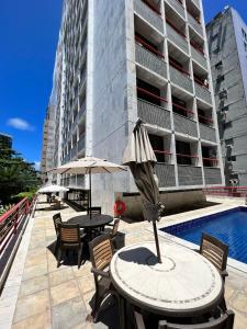 a table with an umbrella and chairs next to a building at Navegantes apartamento in Recife +17 photos