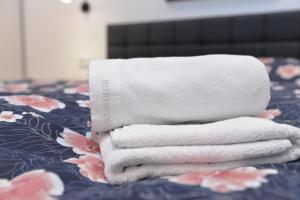 a pile of towels sitting on top of a bed at Room Marsonia in Slavonski Brod