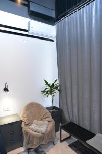 Habitación con silla, escritorio y planta en Room Marsonia, en Slavonski Brod