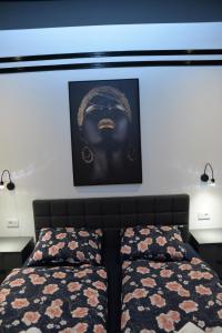 a bedroom with two beds and a picture on the wall at Room Marsonia in Slavonski Brod