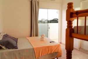 1 dormitorio con 1 cama con manta naranja en Pousada Simples Jose, en Cachoeira Paulista