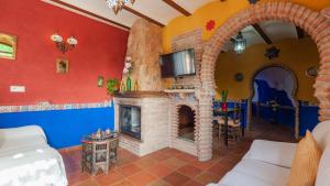 ein Wohnzimmer mit einem Kamin und einem TV in der Unterkunft Cueva del Tito Hinojares by Ruralidays in Hinojares