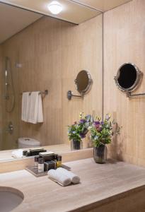 ein Bad mit einem Waschbecken und einem Spiegel in der Unterkunft Dan Jerusalem Hotel in Jerusalem