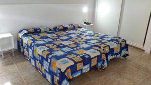 a bedroom with a bed with a blue and yellow quilt at Apartamentos Chinyero in Puerto de la Cruz