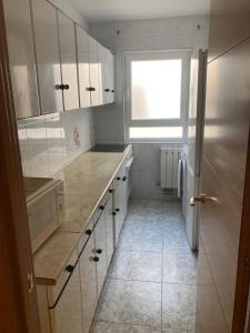 uma cozinha com armários brancos e uma janela em Habitación doble en apartamento de 3 habitaciones em Salamanca