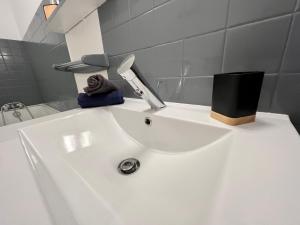 a white bathroom sink with a knife on it at La petite Venise du Loir in Vendôme