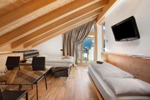 a living room with a couch and a tv at Olympic Chalet 13 in Bormio