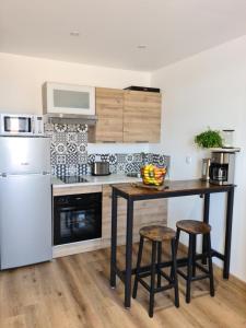 une cuisine avec une table et deux tabourets dans l'établissement La P'tite Bas-Rivière, à Blois