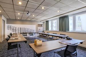 une salle de classe avec des tables et des chaises dans une salle dans l'établissement Hôtel Mercure Marne-la-Vallée Bussy St Georges, à Bussy-Saint-Georges