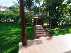 un jardin avec un chemin dans la pelouse dans l'établissement Casa Praia do Forte Bahia Jardim Piscina Churrasco, à Praia do Forte