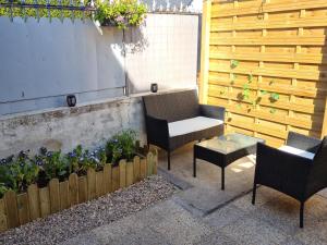 - une terrasse avec 2 chaises, une table et des fleurs dans l'établissement La P'tite Bas-Rivière, à Blois