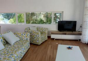 sala de estar con 2 sofás y TV de pantalla plana en Villa la Perle, piscine privée, vue sur le lagon, en Mahébourg