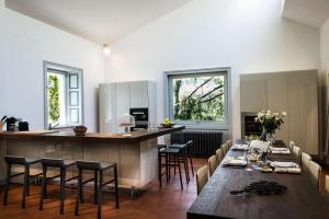 una grande cucina con tavolo e sedie lunghi di Villa delle Fiabe - Homelike Villas a Ossuccio